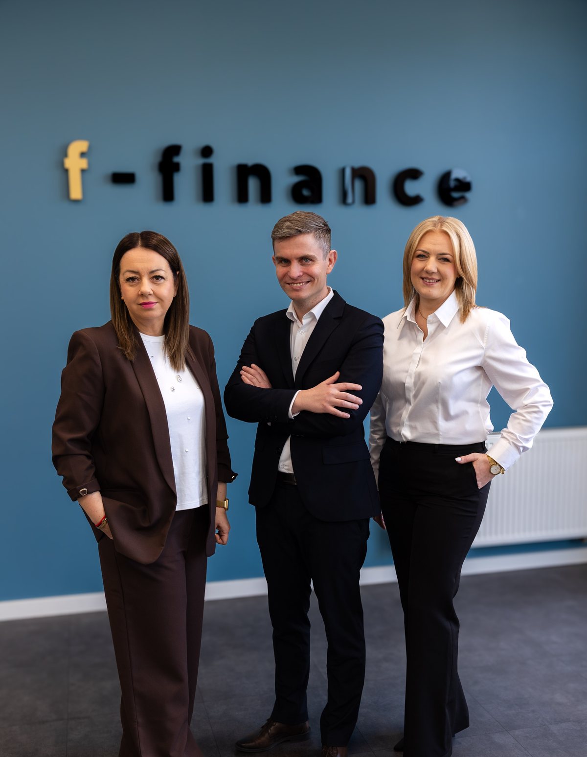 Zespół F-FINANCE przy ścianie z logo firmy: Agnieszka Mroczek, Piotr Rusinowski i Sylwia Pąśko